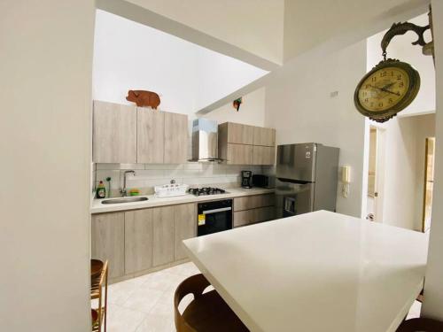kuchnia z białym stołem i zegarem na ścianie w obiekcie Hermoso apartamento en Envigado w mieście Envigado