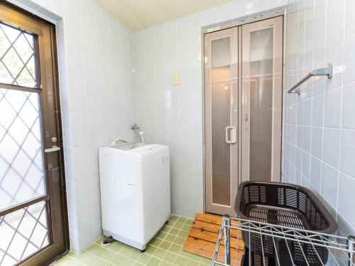 uma casa de banho com um pequeno frigorífico e um chuveiro em AGARI 伊江島 Ie Island em Ie