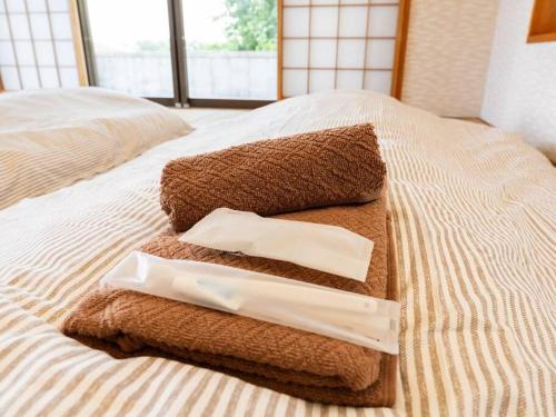 una pila de toallas sentadas encima de una cama en AGARI 伊江島 Ie Island en Ie