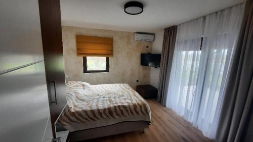 ein kleines Schlafzimmer mit einem Bett und einem Fenster in der Unterkunft Boletov raj lux in Čurug