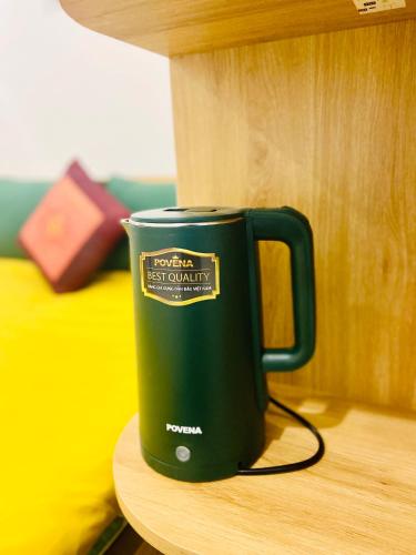 a green coffee cup sitting on a table at Hanoi Cozy Homestay Long Biên in Hanoi
