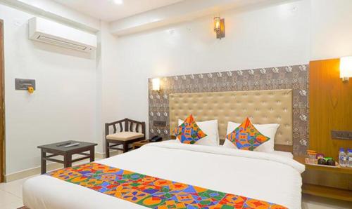 a bedroom with a large white bed and a desk at FabHotel Palash in Dānāpur