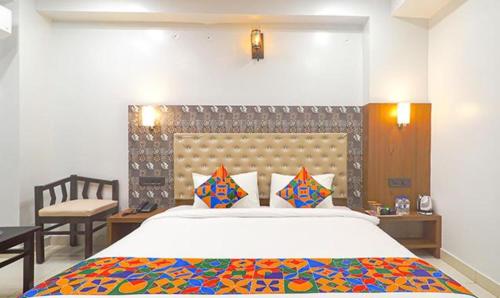 a bedroom with a large bed and a chair at FabHotel Palash in Dānāpur