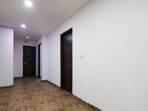 een lege hal met witte muren en een zwarte deur bij RD HOTEL in New Delhi