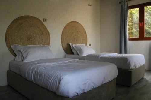 1 dormitorio con 2 camas y ventana en Riad Nizwa en Nizwa