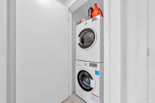 a washing machine and a washer and dryer in a room at Kind One Bedroom Apartment in North Vancouver