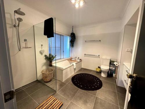 a bathroom with a shower and a sink and a toilet at Palm Breeze - 4 bedroom -Walk to the beach in Bargara