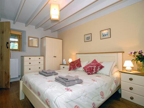 a bedroom with a bed with towels on it at Rias Cottage in Landshipping