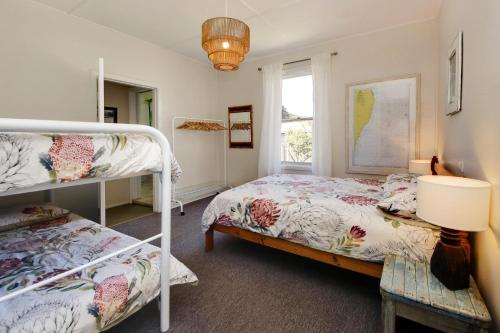 a bedroom with two bunk beds and a window at Muller's Cottage at Hat Head (Pet Friendly) in Hat Head