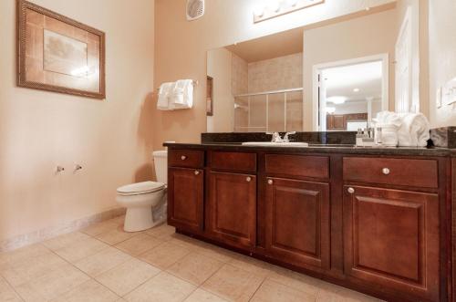 uma casa de banho com um lavatório, um WC e um espelho. em 1351TT Unit 8407 - Tuscana Resort em Kissimmee