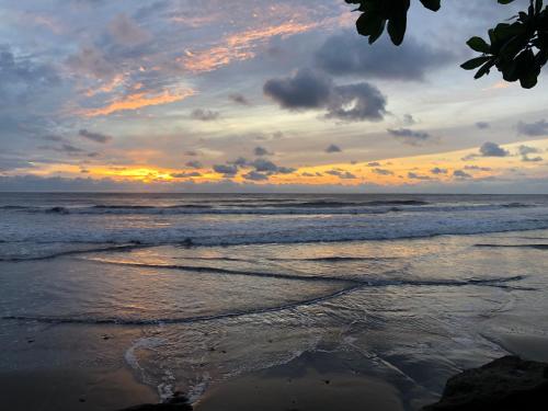 a sunset on the beach with the ocean at El Marabu Chill'n Surf in Aposentillo
