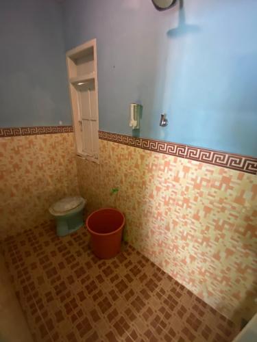 a bathroom with a toilet and a bucket at Ocean house karimunjawa in Karimunjawa