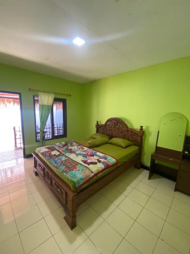 1 dormitorio con 1 cama en una habitación con paredes verdes en Ocean house karimunjawa en Karimunjawa