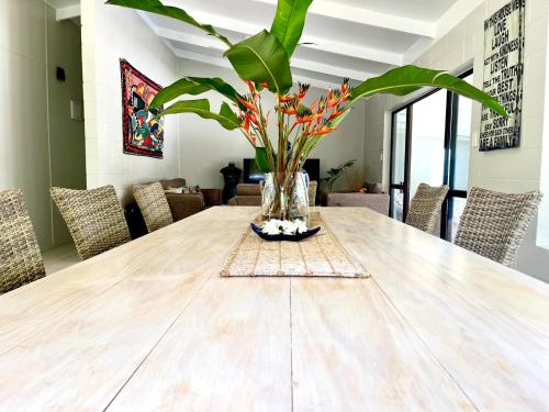 a dining room table with a vase with a plant at Tereora Heights Pool Retreat in Avarua