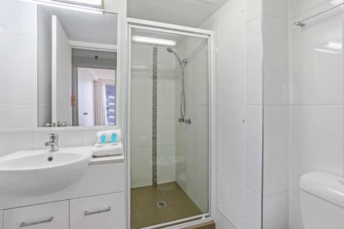 a white bathroom with a sink and a shower at Boulevard North Holiday Apartments in Gold Coast