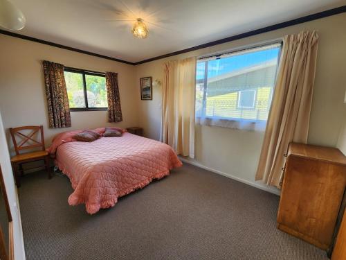 a bedroom with a bed and a large window at Manapouri Holiday Park in Manapouri