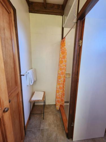 a small room with a door and a small stool at Manapouri Holiday Park in Manapouri