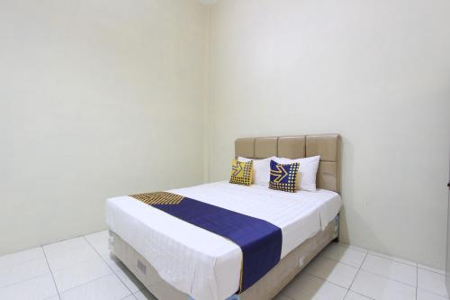 a bedroom with a bed with two pillows on it at SPOT ON 93245 Guet House Mulia Dua Syariah in Klaten