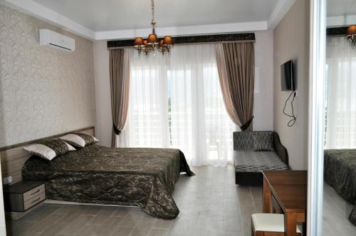 Apartments Yalta Marmaris في يالطا: غرفه فندقيه بسرير وكرسي