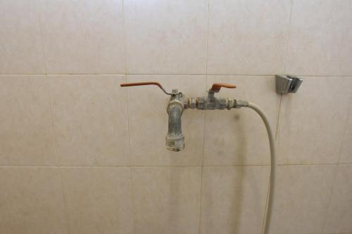 uma torneira de chuveiro numa parede de azulejos na casa de banho em OYO Life 93247 Pondok Pariwisata em Mataram