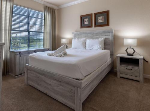 una camera da letto con un grande letto con un orsacchiotto sopra di 8000TW Unit 4403- Tuscana Resort a Kissimmee