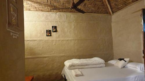 Golpo Katha في لاتاغري: غرفة نوم عليها سرير وفوط