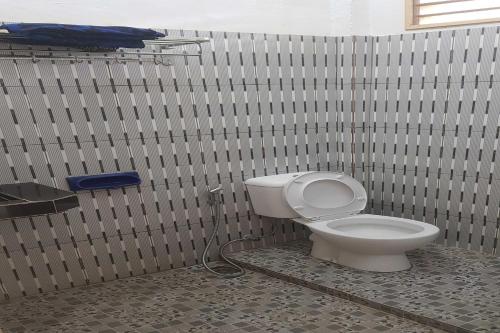 La salle de bains est pourvue de toilettes blanches. dans l'établissement OYO 93268 Maradona Guest House, à Medan