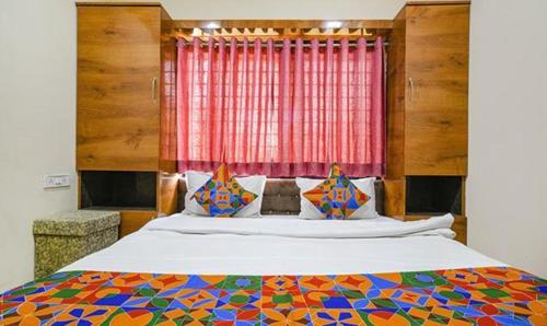 a bedroom with a large bed with a colorful bedspread at FabHotel Royal Palace in Indore