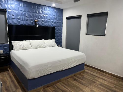 グアダラハラにあるHotel don Boscoの青い壁のベッドルーム1室