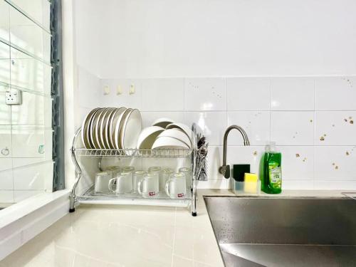 un estante de platos en una cocina junto a un fregadero en O3 1-12Pax Cozy Home Setia Alam SCCC TV&WiFi Pool, en Shah Alam