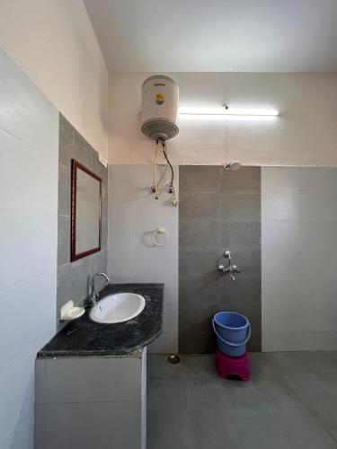 a bathroom with a sink and a blue toilet at The Patel Stadium Hotel 1 Km from Bus Stand and 2 Km from Railway station in Ajmer
