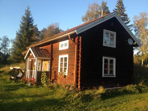 a small log cabin in a field of grass at Rustika strandstugor utanför Rättvik in Rättvik
