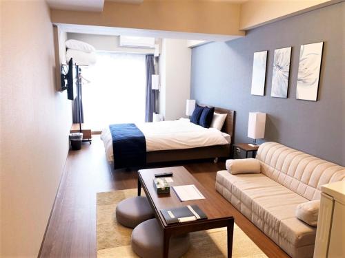 a living room with a bed and a couch at RLiS-house Shin-Osaka Kita - Vacation STAY 9521 in Osaka