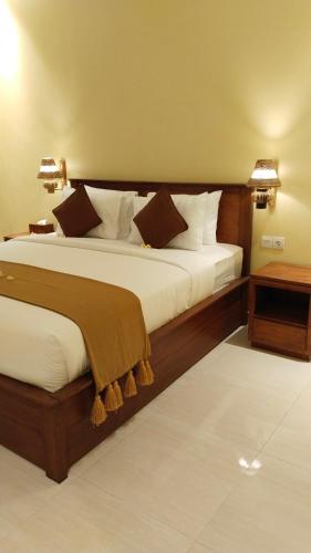 a bedroom with a large bed with white sheets at D'Natha Villa Ubud in Ubud
