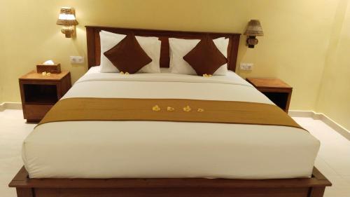 a large bed in a room with two night stands at D'Natha Villa Ubud in Ubud