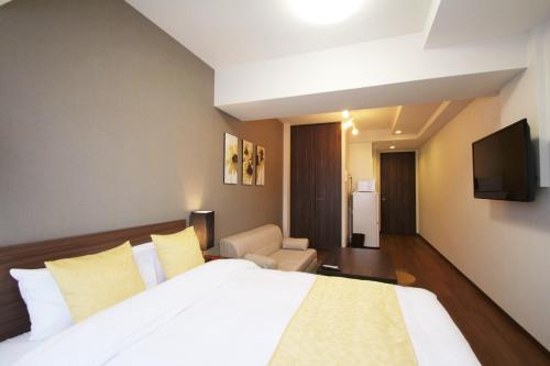 een hotelkamer met een bed en een televisie bij RLiS-house Shin-Osaka Kita - Vacation STAY 9529 in Osaka
