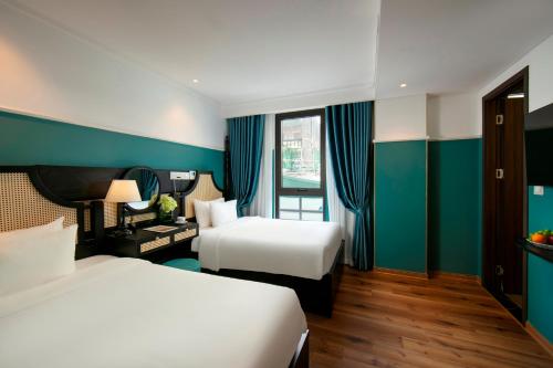 a hotel room with two beds and blue walls at Hotel De Rond in Hanoi