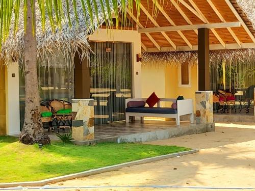 a house with a porch with a couch and chairs at BLUE WAVES kite surfing beach resort in Kalpitiya
