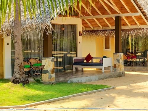 Casa con porche con sofá y sillas en BLUE WAVES kite surfing beach resort, en Kalpitiya