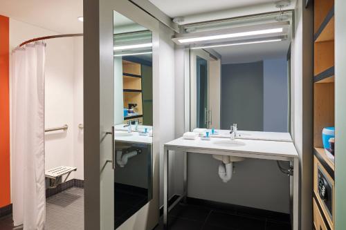 a bathroom with a sink and a mirror at Aloft South Bend in South Bend