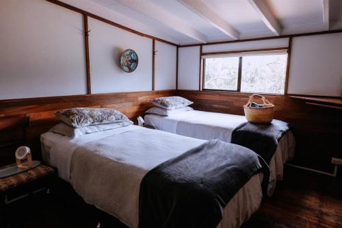 a room with two beds and a window at Cottage 3 - The Row in Forest Grove
