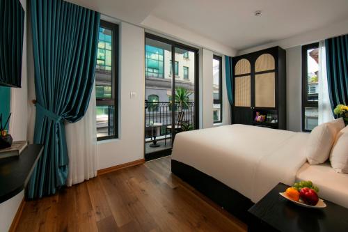 a bedroom with a bed and a couch and windows at Hotel De Rond in Hanoi