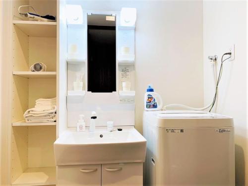een kleine badkamer met een wastafel en een spiegel bij RLiS-house Shin-Osaka Kita - Vacation STAY 9516 in Osaka