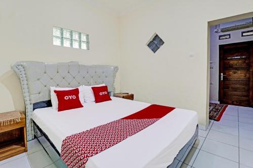 Sumedang的住宿－OYO Life 91480 Putridapisa Syariah，卧室配有带红色枕头的白色床