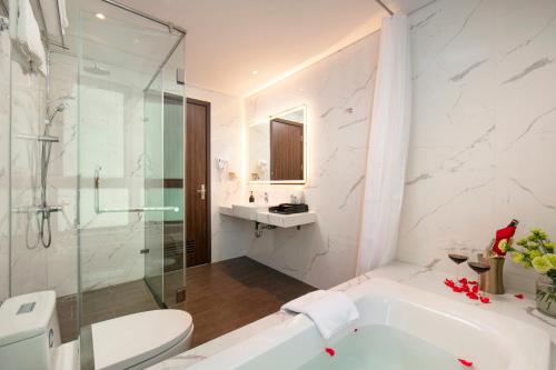 La salle de bains est pourvue d'une baignoire, d'une douche et de toilettes. dans l'établissement Hotel De Rond, à Hanoï