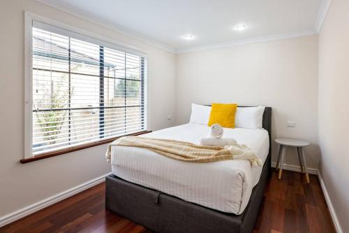 a bedroom with a large bed and a window at Luxury Waterfront Canal Estate With Private Jetty - Pet Friendly in Busselton