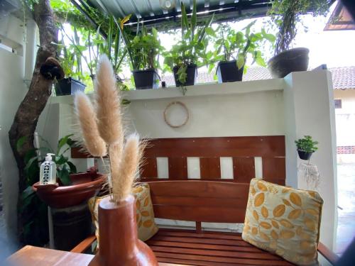 a bench in a room with potted plants at Coliving Jogja SWEET HOME Kost Lengkap di Jogjakarta in Yogyakarta