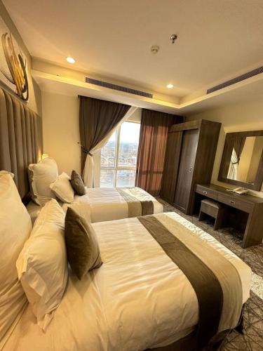 Habitación de hotel con 2 camas y ventana en Lophorina Hotel en Al ‘Abābīd
