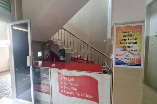 a stair case with a red counter and a staircase at Capital O 93250 Hotel Tirta Kencana 2 Baturaden in Banyumas