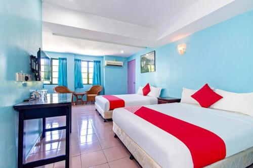 2 letti in una camera con pareti blu di Lotus Hotel Seremban Near Palm Mall & KPJ Seremban a Seremban